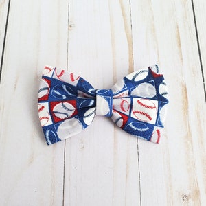 May include: A white bow tie with a blue and red baseball pattern.