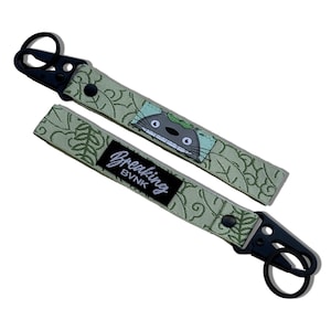 May include: Green and black keychain with a cartoon character and the text "Breaking BVNK".