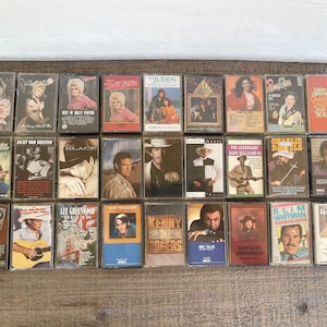 May include: A collection of 20 vintage cassette tapes featuring country music artists such as Kenny Rogers, The Judds, and Waylon Jennings.