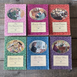 Puede incluir: Un conjunto de seis libros de bolsillo vintage con portadas coloridas que muestran ilustraciones de niños. Los títulos son "Una Chica Anticuada", "Rosa en Flor", "Ocho Primas", "Jack y Jill", "Los Chicos de Jo" y "Hombres Pequeños". Todos los libros son de Louisa May Alcott.