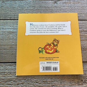 May include: The back cover of a children's book featuring Corduroy the bear dressed as a pumpkin. The text reads "Halloween is almost here! Corduroy and his friends love this time of year - the pumpkins, the candy, and of course, the costumes for trick-or-treating! What is Corduroy going to wear this Halloween? And what if everyone else picks the best costumes first?"