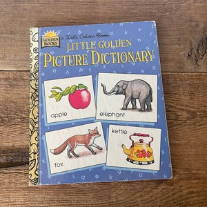 Puede incluir: Un libro de bolsillo Little Golden Book Picture Dictionary con ilustraciones de una manzana, un elefante, una tetera y un zorro. La portada del libro es azul con acentos amarillos y rojos.