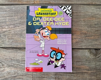 Może przedstawiać: Książka dla dzieci zatytułowana "Laboratorium Dextera #3: Dr. Dee Dee & Dexter Hyde" z ilustracjami z kreskówek. Okładka jest fioletowa z żółtym i białym tekstem. Logo Scholastic znajduje się na dole.