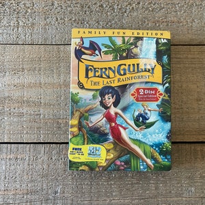Op de afbeelding: Een DVD-hoes voor de film "FernGully: Het Laatste Regenwoud" met een label voor een familie-editie. De hoes heeft een cartoonafbeelding van een fee met groen haar en een rode jurk die op een tak staat. De tekst "2-Disc Special Edition" is zichtbaar op de hoes.
