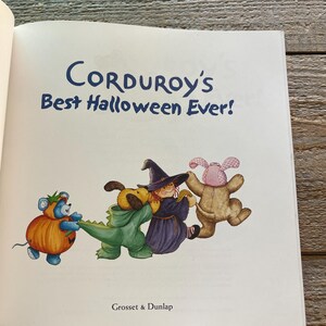 May include: A children's book cover featuring a group of plush toys dressed in Halloween costumes. The book title is "Corduroy's Best Halloween Ever!" and the publisher is "Grosset & Dunlap".