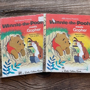 Könnte beinhalten: Zwei antike Little Golden Books mit Winnie Puuh. Die Bücher tragen den Titel "Winnie Puuh trifft Gopher" und basieren auf Geschichten von A.A. Milne. Die Cover zeigen Illustrationen von Winnie Puuh und einem Gopher.