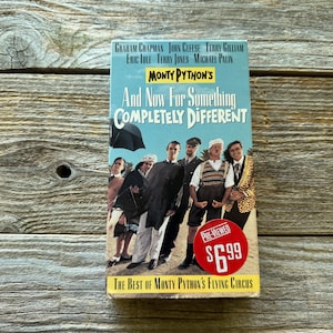 May include: A vintage VHS tape of Monty Python's "And Now For Something Completely Different." The cover shows a group of men in various outfits, with the title in white and blue. The tape is pre-viewed.