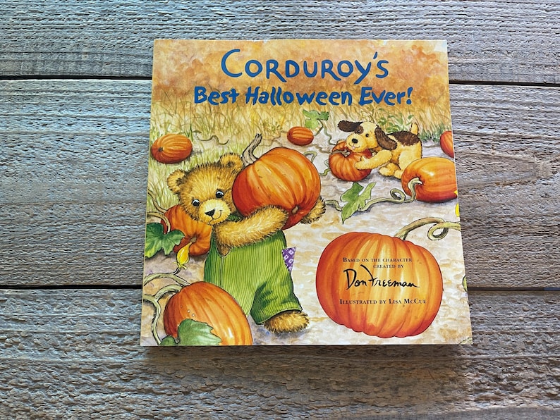 May include: A children's book cover featuring a brown teddy bear holding a large orange pumpkin. The book title is "Corduroy's Best Halloween Ever!" and is based on the character created by Don Freeman. The book is illustrated by Lisa McCue.