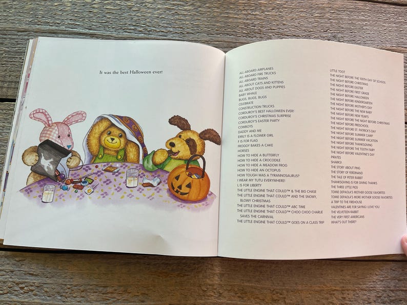 May include: Three plush toys, a pink bunny, a brown bear, and a brown dog, are sitting at a table with candy and a glass of milk. The text "It was the best Halloween ever!" is visible on the page. The page is from a children's book.