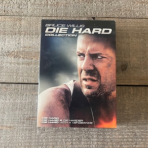 K&ouml;nnte beinhalten: Eine DVD-Sammelbox mit Bruce Willis auf dem Cover. Der Titel lautet "Die Hard Collection" und die enthaltenen Filme sind "Die Hard", "Die Hard 2: Die Harder" und "Stirb Langsam - Jetzt erst recht".