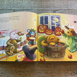 May include: A children's book illustration of a Halloween party with stuffed animals dressed in costumes. A pink bunny with a blue bow, a brown bear wearing a green shirt, a blue bear with a black hat, and a brown dog wearing a green costume. The animals are gathered around a table with food and drinks. There are pumpkins and apples on the table. The text on the page reads "Cadbury thought and thought. He thought all through the party. It was a really fun party,  most  they gobbled for apples and carved jack-o-lanterns and ate cookies and punch."