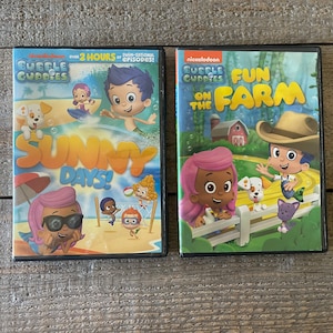 May include: Two DVD cases featuring the Nickelodeon cartoon Bubble Guppies. The left case features the characters on a beach with the text "Sunny Days!" The right case features the characters on a farm with the text "Fun on the Farm".