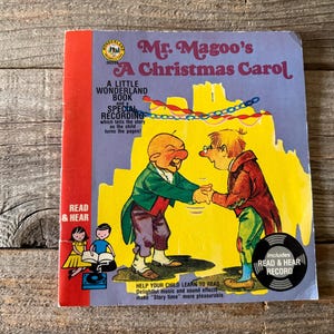 Puede incluir: Libro infantil vintage titulado "Mr. Magoo's A Christmas Carol". La portada presenta ilustraciones de dibujos animados de dos personajes dándose la mano sobre un fondo amarillo. Incluye un "Read & Hear Record". El libro es un "Little Wonderland Book".