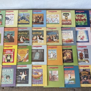 Puede incluir: Una colección de 36 libros infantiles con portadas coloridas que presentan diversas ilustraciones y títulos. Los libros están dispuestos en cuatro filas de nueve libros cada una. Los libros están todos publicados por Scholastic.