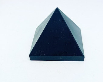 Könnte beinhalten: Eine schwarze Obsidianpyramide, ein Kristall, der zur Erdung und zum Schutz verwendet wird.