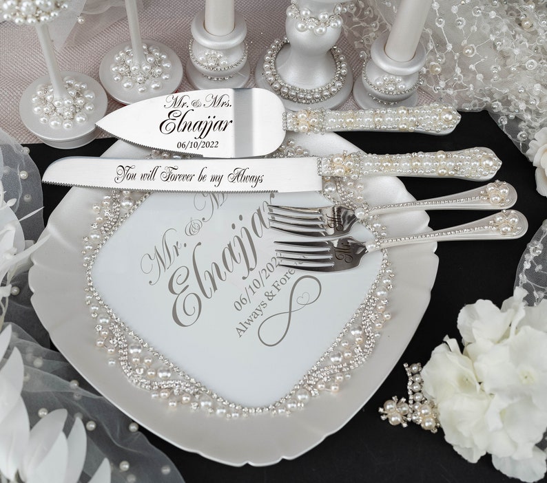 May include: White ceramic cake plate with pearl trim and a silver cake knife and fork set. The plate is personalized with the text "Mr. & Mrs. Elnajjar 06/10/2022 Always & Fore" and the cake knife has the text "You will Forever be my Always".