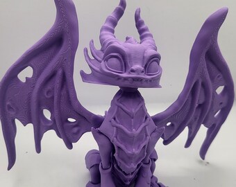May include: A purple 3D printed dragon figurine with wings outstretched. The dragon has a detailed face with large eyes and a small mouth.