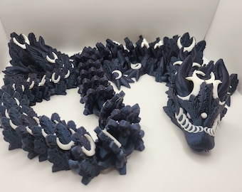 Könnte beinhalten: Eine dunkelblaue 3D-gedruckte Drachenfigur mit weißen Akzenten. Der Drache ist in einer Spirale zusammengerollt, mit erhobenem Kopf. Die Schuppen des Drachen sind detailliert und strukturiert.
