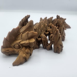 May include: A chain of brown, 3D printed dragon heads, each with intricate details and a textured surface.