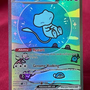 May include: A holographic Mew ex trading card featuring a light blue Mew character inside a circular bubble. The card displays the text Mew ex, 180 HP, Ability Restart, and Genome Hacking, with colorful rainbow foil accents and small illustrated Pokémon figures.
