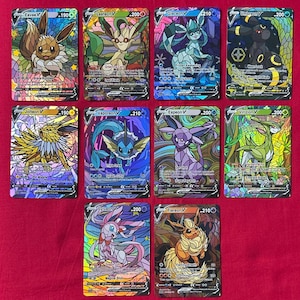 May include: Ten Pokémon V cards are displayed, each showcasing a different character in a stained-glass style design. The cards feature various colours, including brown, green, blue, purple, and yellow. Each card displays the character's name and a number.