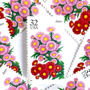 May include: A collection of eight vintage US postage stamps featuring a pink and red aster flower with the text "32 USA" and "Aster" on each stamp.