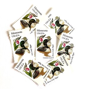May include: Six vintage United States postage stamps featuring a common loon and a showy lady slipper flower. The stamps are from the state of Minnesota and are each worth 20 cents.