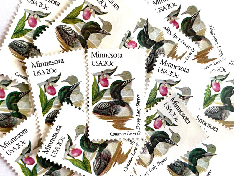 May include: A collection of vintage Minnesota postage stamps featuring a common loon and a showy lady slipper flower. Each stamp is 20 cents and features the text "Minnesota USA 20c".