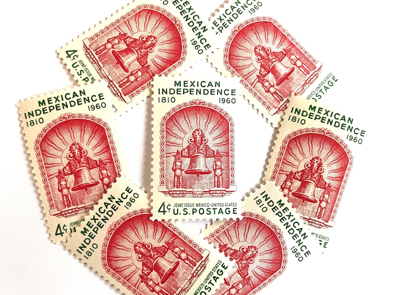 May include: A collection of eight vintage United States postage stamps commemorating the 150th anniversary of Mexican Independence in 1960. The stamps feature a red and white design with a bell and two figures, and the text "MEXICAN INDEPENDENCE 1810 1960" in green.