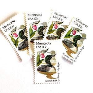 May include: Five vintage postage stamps featuring a common loon and a showy lady slipper orchid. The stamps are from Minnesota and are each valued at 20 cents.