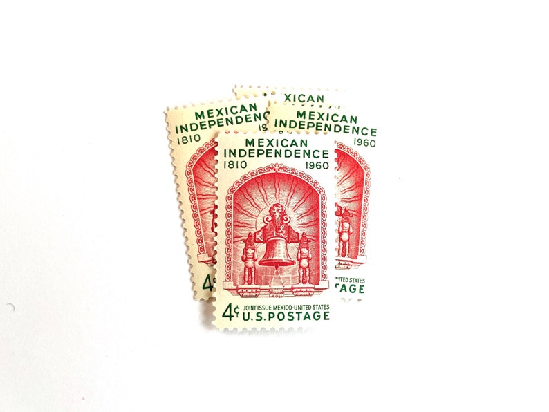 May include: Four vintage United States postage stamps commemorating the 1960 anniversary of Mexican Independence. The stamps feature a red and white design with a bell and the text "Mexican Independence 1810 1960".