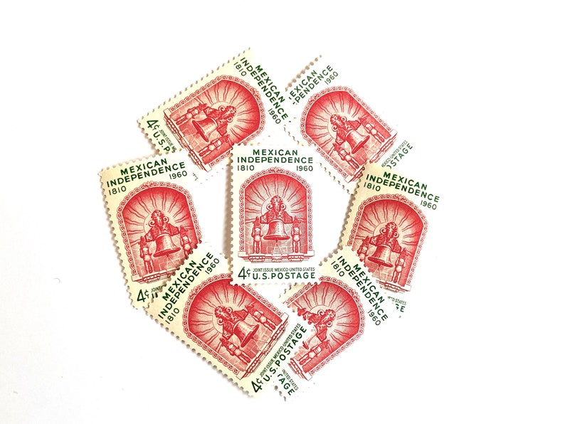 May include: A collection of eight vintage postage stamps commemorating the 150th anniversary of Mexican Independence. The stamps feature a red and green design with the text "Mexican Independence 1810-1960" and a depiction of a bell.