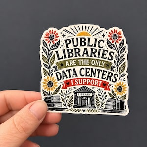 May include: A die-cut sticker featuring the text PUBLIC LIBRARIES ARE THE ONLY DATA CENTERS I SUPPORT. The design includes a central library building, stacks of books, and sunflowers in red, yellow, and green on a cream background with black ink.