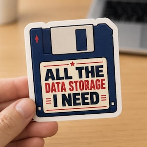 May include: A square sticker shaped like a dark blue floppy disk with a white label in the centre. The label features a red star and the text ALL THE DATA STORAGE I NEED in bold blue and red lettering, with horizontal lines on the sides.
