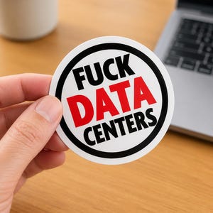 May include: A circular sticker with a white background and a thick black circular border. The text FUCK DATA CENTERS is printed in the center, with the word FUCK in black, DATA in red, and CENTERS in black, all in a bold sans-serif font.