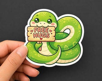 Può includere: Un adesivo in vinile fustellato raffigurante un serpente verde brillante con il ventre color crema chiaro, avvolto in un cerchio. Il serpente tiene in mano un piccolo cartello in legno marrone chiaro con la scritta FREE HUGS in lettere rosa scuro.