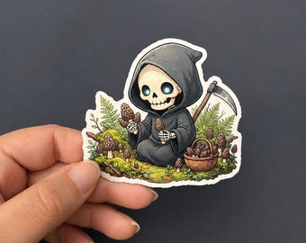 Può includere: Un adesivo fustellato raffigurante uno scheletro in stile cartoon che indossa una tunica scura con cappuccio e tiene in mano una falce. Lo scheletro è circondato da muschio verde, felci e spugnole marroni, con un cesto di vimini pieno.
