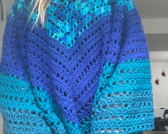 Puede incluir: Un suéter de punto de ganchillo azul, turquesa y azul verdoso con un corte holgado y un escote en V.
