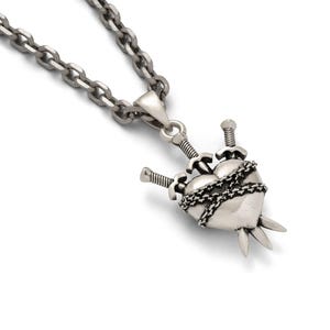 Silver heart pendant with 3 swords going through it and wrapped in chain on white background