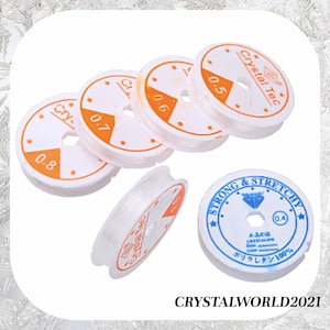 May include: Five spools of clear elastic string for jewelry making. The spools are white with orange and black text that reads "Crystal Tec" and "Strong & Stretchy". The spools are labeled with different sizes: 0.4, 0.5, 0.6, 0.7, and 0.8.