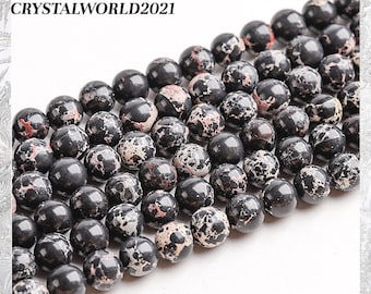 May include: A strand of black and white speckled round beads. The beads are approximately 8mm in diameter and have a smooth, polished finish.