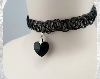 May include: Black choker necklace with a black crystal heart pendant.