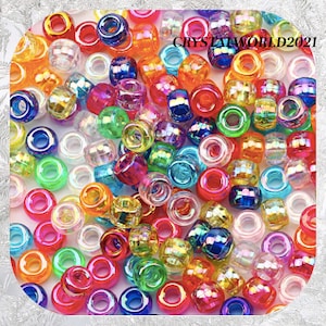 May include: A large assortment of iridescent plastic beads in various colours, including red, orange, yellow, green, blue, purple, and pink. The beads are all round and have a hole in the centre.  CRYSTALWORLD2021 is printed on the image.