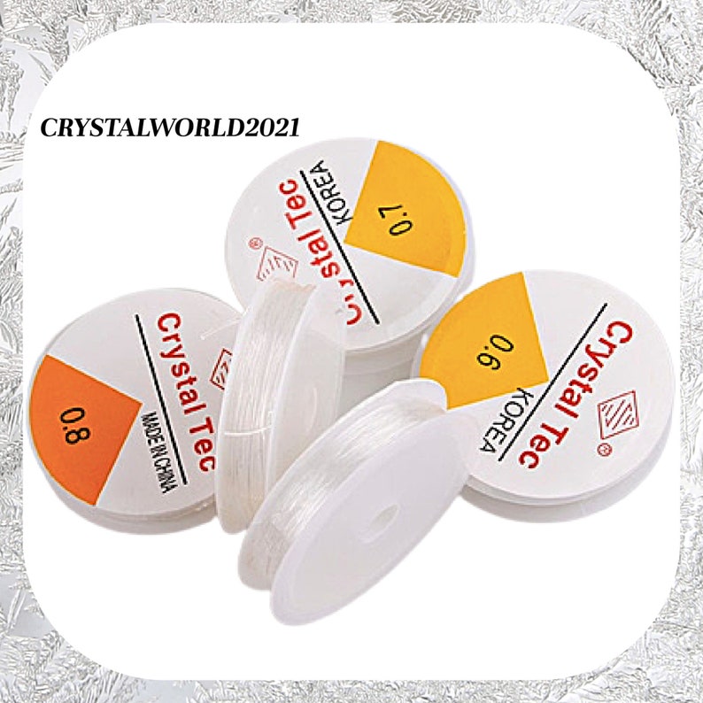 May include: Four spools of clear elastic thread, each with a yellow label that reads "Crystal Tec" and "KOREA". The labels also indicate the thread thickness: 0.6, 0.7, and 0.8 mm. One spool has a label that reads "Crystal Tec" and "MADE IN CHINA".