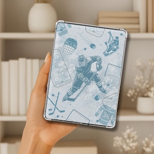 May include: A light blue tablet case with a hockey design. The case shows illustrations of hockey players, pucks, skates, and other hockey graphics. The design is set against a textured, light blue background.
