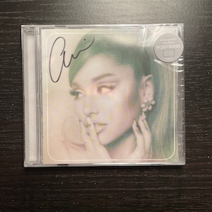 Ariana Grande posiciona CD assinado e fechado