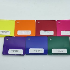May include: Eight square pieces of transparent acrylic in different colors: yellow, orange, red, pink, purple, blue, green, and clear. Each piece has a white label with the color name printed on it.