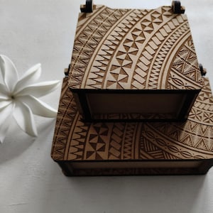 May include: Two wooden boxes with intricate geometric patterns carved into the surface. The boxes are stacked on top of each other, with the top box slightly smaller than the bottom box.