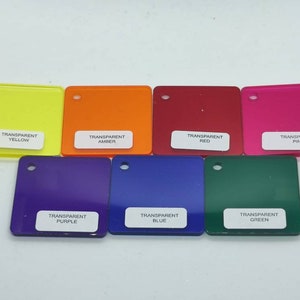May include: Eight square pieces of transparent acrylic in different colors: yellow, orange, red, pink, purple, blue, green, and clear. Each piece has a white label with the color name printed on it.