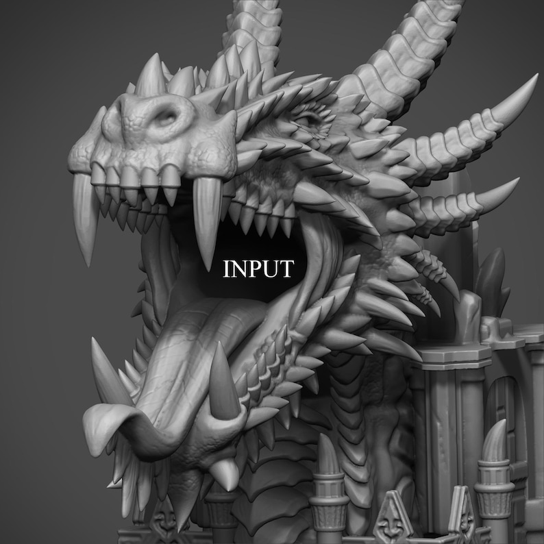 Puede incluir: Una cabeza de drag&oacute;n renderizada en 3D en escala de grises con la boca abierta, dientes afilados y escamas texturizadas. La palabra "INPUT" est&aacute; impresa en la boca del drag&oacute;n. La cabeza del drag&oacute;n es el punto focal de la imagen.